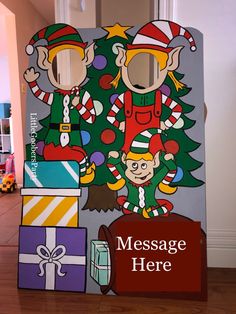 a cardboard christmas tree with two elfs on it