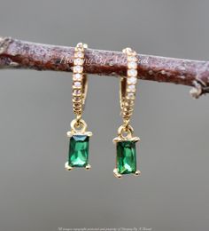 "Lovely little earrings made using premium CZ jewels and gold hoops. The earrings feature small, huggie style hoops. They are paved along the outer edge with clear CZ jewels. They connect to a single baguette jewel, in emerald green. Hoops are 11mm (outside dimension) while entire earring is roughly 3/4\". Hoops are 14K gold over brass, with an anti tarnish coating.  ** Please read dimensions carefully, close up photos make items appear larger than life.   MADE TO MATCH: https://www.etsy.com/listing/1264853261/new-tiny-gold-emerald-green-cz-tennis?click_key=26f1f02be7bfcd53d23a954b5eec3a33f2784bac%3A1264853261&click_sum=173e35bf&ga_search_query=emerald%2Bcubic&ref=shop_items_search_3&pro=1&sts=1 https://www.etsy.com/listing/1111470305/new-tiny-gold-emerald-green-cz-tennis?click_key=cf77325 Emerald Hanging Earrings, Rectangular Crystal Earrings For Party, Rectangular Cubic Zirconia Earrings For Gifts, Earrings Rectangle, Pave Earrings, Prom 2024, Larger Than Life, Hoops Gold, Emerald Earrings