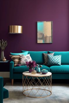 a living room with purple walls and teal furniture