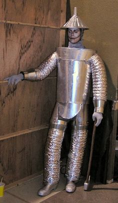 a man dressed as a knight standing next to a wooden wall