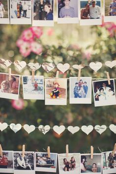 several photos hanging from clothes pins on a string with hearts attached to them and pictures pinned to the line