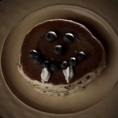 a chocolate cake with white frosting and blueberries on top