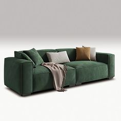 a green couch with pillows on it and a blanket draped over the armrests