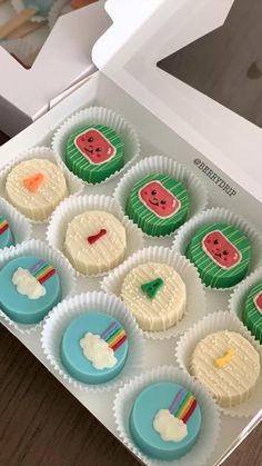 cupcakes decorated with watermelon and rainbow colors in a box on a table