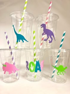 six plastic cups with different colored dinosaur drinking straws