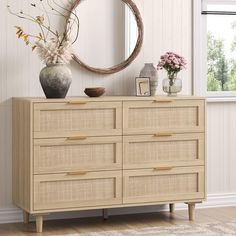 a white dresser sitting next to a window with a mirror on it's side