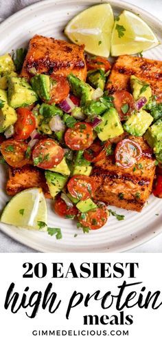 a white plate topped with tofu and avocado next to a lemon wedge