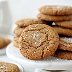 several cookies are stacked on a plate with powdered sugar in the middle and one cookie has been cut into smaller pieces