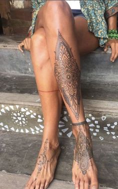 a woman sitting on the steps with tattoos on her legs and feet, both showing