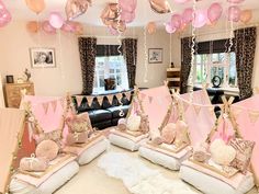 pink and gold birthday party decorations in a living room with white fluffy rugs on the floor