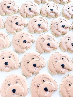 some cookies with pink frosting and black eyes are arranged in rows on a white surface