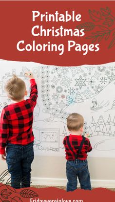 two young boys are drawing on the wall with christmas coloring pages