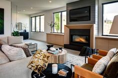 a living room filled with furniture and a flat screen tv mounted on the wall above a fireplace