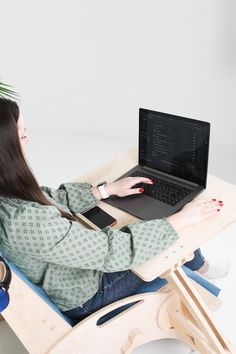 a woman sitting at a desk using a laptop computer