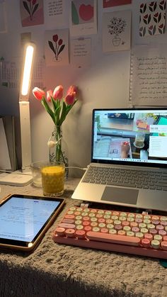 an open laptop computer sitting on top of a desk next to a phone and keyboard