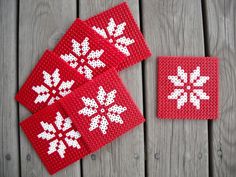 crocheted coasters with snowflakes on them sitting on a wooden surface