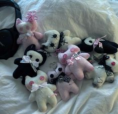 a bunch of stuffed animals that are laying down on a bed next to headphones