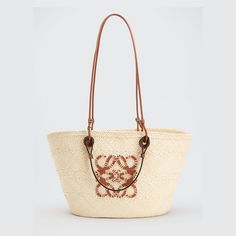 Loewe basket tote bag in woven Iraca palm leaf and calf leather. From the Paula's Ibiza Collection. Two sets of top handles. Anagram logo at front. Made in Spain. Designer Straw Bag With Braided Handles For Beach, Designer Straw Bucket Bag With Leather Handles, Designer Straw Tote Bag With Bamboo Handle, Designer Straw Bucket Bag With Braided Handles, Designer Natural Basket Straw Bag, Designer Natural Color Basket Straw Bag, Designer Bucket Bag With Leather Handles In Natural, Designer Natural Bucket Bag With Leather Handles, Designer Natural Straw Bag With Bamboo Handle