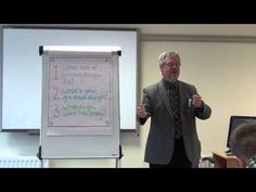 a man standing in front of a whiteboard giving a presentation