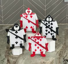 four different sized playing cards made out of toilet paper on a counter with tile wall in the background