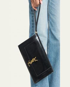 Saint Laurent "Cassandra" pouch wristlet in calfskin leather     Features signature YSL logo lettering     Wristlet strap    Flap top with snap closure     Interior, one slip pocket     Approx. 6.2"H x 9.4"W x 1.5"D    Made in Italy Ysl Logo, Leather Wristlet, Snap Closure, Calf Skin, Saint Laurent, Tops Designs, Pouch, Italy, Luxury Fashion