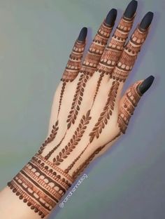 a woman's hand with henna tattoos on it