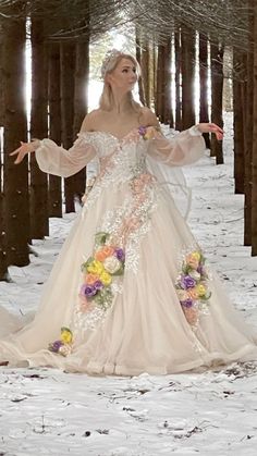 a woman in a wedding dress standing in the snow