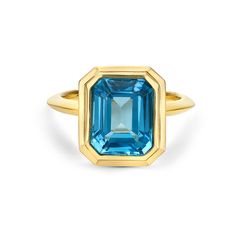 Make a bold statement with the 14K Yellow Gold Swiss Blue Topaz Ring. This exquisite piece features a breathtaking 4.35 carat emerald-cut Swiss blue topaz, securely nestled within a sleek bezel setting. The vibrant blue gemstone is beautifully accentuated by the warm glow of the yellow gold band, creating a harmonious blend of color and elegance. Perfect for adding a touch of sophistication to any ensemble, this ring is a timeless addition to any jewelry collection. Luxury Yellow Gold Topaz Ring Fine Jewelry, Modern Luxury Yellow Gold Topaz Ring, Diamond Cuff Bracelet, Swiss Blue Topaz Ring, Gold Rings Stackable, Diamond Fashion Rings, Swiss Blue Topaz, Sterling Silver Hoop Earrings, Sterling Silver Necklace Pendants