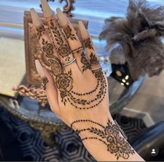 a woman's hand with henna tattoos on it