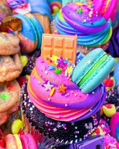 colorful cupcakes with frosting and sprinkles all over the place