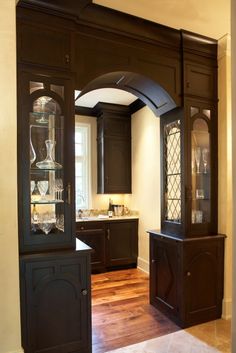 an empty kitchen with wooden floors and cabinets in it's centerpiece, along with a glass door that leads to the dining room