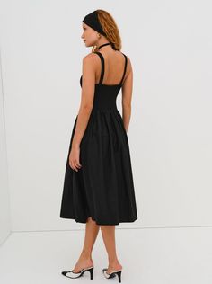 The Billie Midi dress by For Love & Lemons is a timelessly elegant dress that will remain in your wardrobe for years to come! This midi dress has a poplin skirt, a knit bodice, and a poplin rosette. Available in both cream and black. Elegant A-line Midi Dress With Smocked Back, Cocktail Dress With Gathered Voluminous Skirt, Cocktail Dress With Voluminous Gathered Skirt, Fitted Ruched Dress With Full Skirt, Fitted Full Skirt Dress With Ruched Details, Formal Dress With Gathered Voluminous Skirt, Ruched Dress With Fitted Bodice And Full Skirt, Spring Dresses With Smocked Back And Voluminous Skirt, Chic Evening Dress With Gathered Skirt