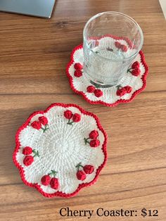 two crocheted coasters with red roses on them