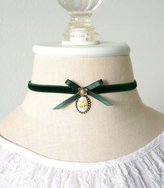 This Victorian style cameo choker necklace is handmade with a soft double sided velvet ribbon in an emerald green color. It features a silk ribbon bow, pearl bead jewel and a beautiful vintage floral cameo with a sweet yellow rose. A lovely gift for girls and women who love to wear romantic historical style jewelry. * Size ~ Adjustable length 12 - 15 inches with extender chain Please check your neck size carefully as I do not accept returns or exchanges on these necklaces. Contact me prior to pu Soft Goth Accessories, Ren Faire Necklace, Velvet Ribbon Choker, Velvet Ribbon Necklace, Handmade Victorian Jewelry, Victorian Gifts, Floral Necklace Jewelry, Cute Chokers, Victorian Jewelry Necklace