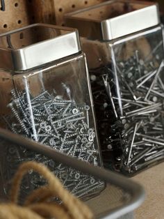 two glass containers filled with lots of screws