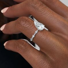 a woman's hand with a diamond ring on her finger and an engagement band