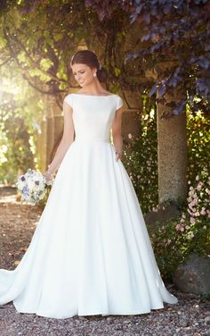 a woman in a white wedding dress standing outside