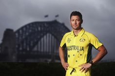 a man standing in front of a bridge with his hands on his hips wearing a yellow jersey