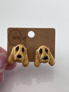 a pair of dog earrings is shown in front of a cardboard card that says lakeside clay