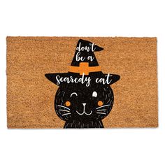 a door mat that says don't be a scary cat with a witches hat on it