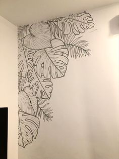 the wall is painted with black and white designs on it's walls, along with a painting of leaves