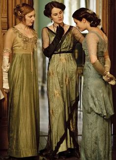 three women in evening dresses talking to each other