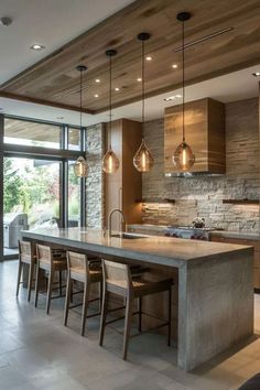 a large kitchen with an island in the middle and lots of lights hanging from the ceiling