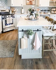 a kitchen with white cabinets and wooden floors