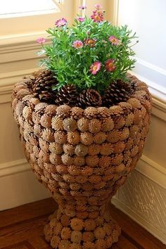 a planter made out of pine cones and flowers