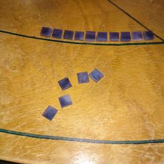 a wooden table topped with blue tiles on top of it