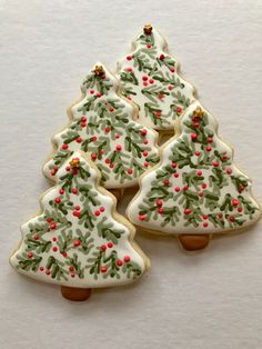 three decorated christmas tree cookies sitting on top of each other