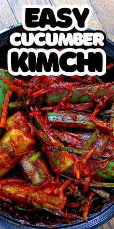 an easy cucumber kimchi recipe in a black bowl on a wooden table