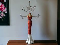 a red and white figurine on top of a wooden table