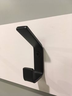 a black door handle on a white wall